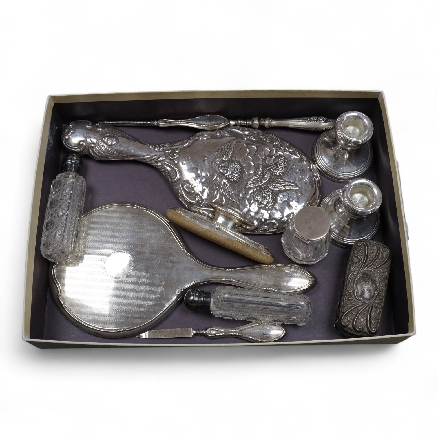 Two silver mounted hand mirrors including Reynold's Angels, Chester, 1899, 26.7cm, together with four silver mounted dressing table implements, a pair of silver mounted dwarf candlesticks and four assorted silver mounted